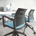 Respaldo ergonómico de silla Spacio negra con ruedas y asiento tapizado en azul